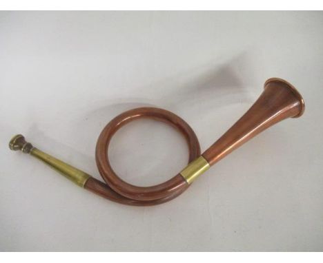 An early 20th century copper and brass single coil hunting horn, the bell 2 1/4"dia, 13 1/2" overall 