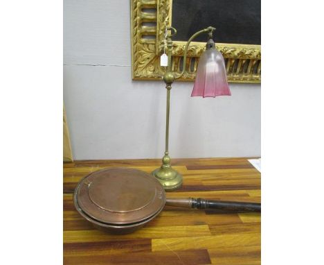 An Edwardian brass table lamp with cranberry and frosted period glass with etched bow and swag decoration, along with a coppe