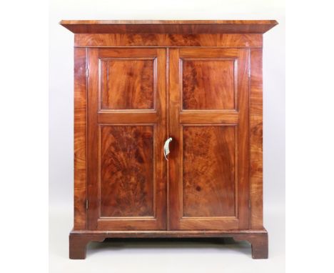 A William IV mahogany cabinet, fitted with shelves enclosed by a pair of panelled doors, on a later shaped apron stand, 116cm