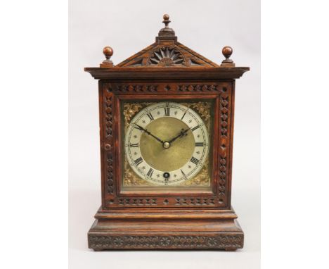 An Edwardian carved oak mantel timepiece, in an architectural style case, brass dial with silvered chapter ring, the movement