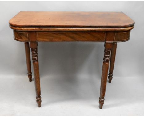 A George III mahogany boxwood strung tea table, with hinged fold over top, on ring turned legs, 94cm wide x 48cm deep x 74cm 