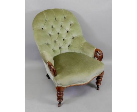 A Victorian mahogany frame button down upholstered armchair, with pierced foliate scroll carved terminals, on turned legs and