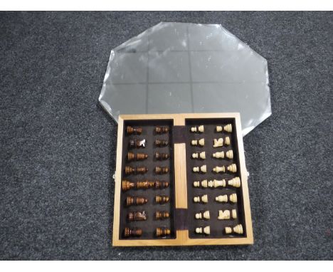 An early 20th century unframed mirror  and a travel chess set 