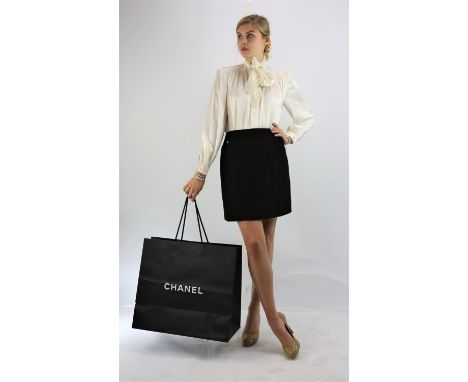 A CHANEL BOUTIQUE classic black wool, black silk-lined mini skirt with silk-lined hip pockets fits UK12-14 (30" waist x 18.5"