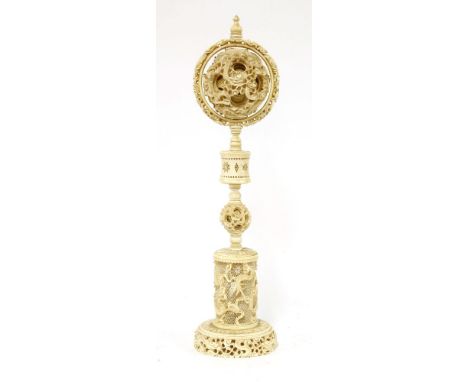 A Chinese ivory ball and stand,late 19th century, the ball exterior carved with dragons amongst clouds and enclosing at least