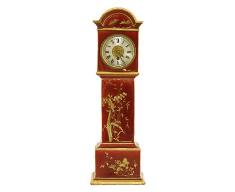 A miniature porcelain longcase clock,early 20th century, with French drum movement, the case gilded with foliage on a red gro