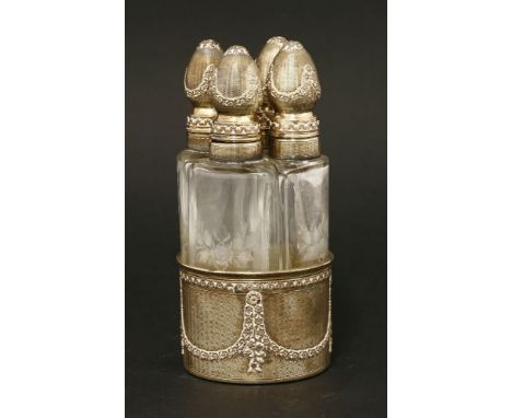 A late 19th/20th century French silver gilt four-bottle perfume set,the wedge-shaped bottles etched with flowers, the silver 