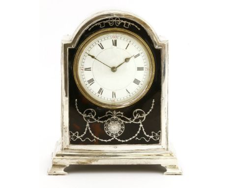 A George V silver mantel clock, Birmingham 1907, the convex enamel dial within a silver inlaid tortoiseshell front, on bracke