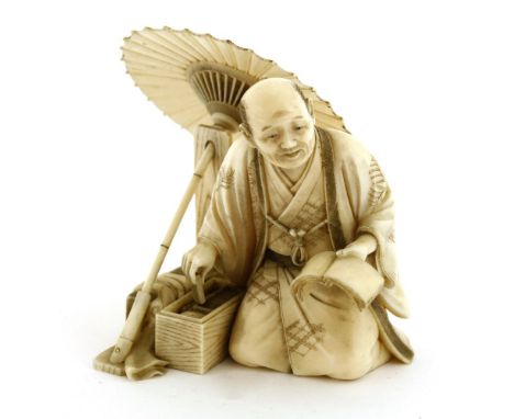 A Japanese ivory okimono,Meiji period (1868-1912), of an umbrella maker, kneeled with a notebook in his left hand, his right 