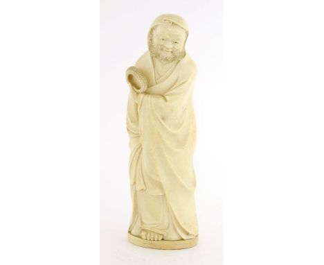 A Chinese ivory figure,c.1900, of Damo standing in long robes, with his left shoe in his left hand, carved seal mark of Damo 