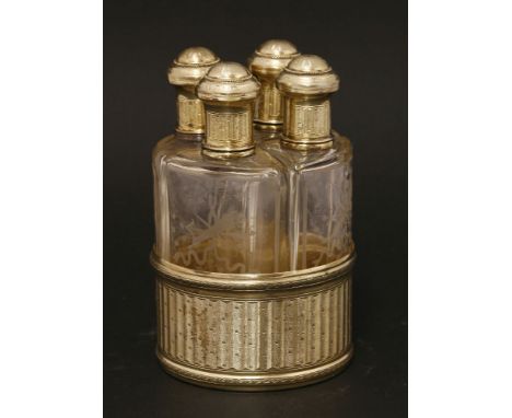 A late 19th/early 20th century French silver gilt perfume bottle stand,maker's mark obscured,of circular form, fitted with fo