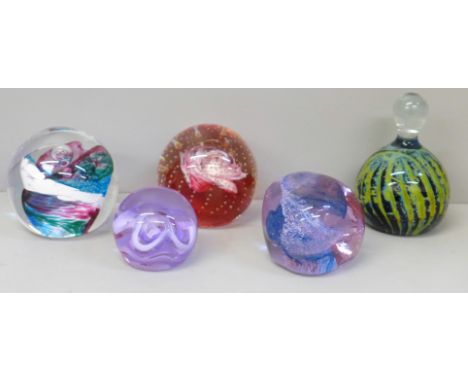 A collection of four Caithness and one Mdina glass paperweights 