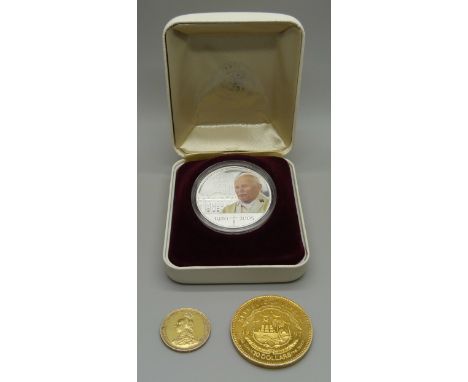 A boxed silver one dollar Pope John Paul II coin, a $10 Liberia silver coin and an 1887 Victoria The Great shilling 