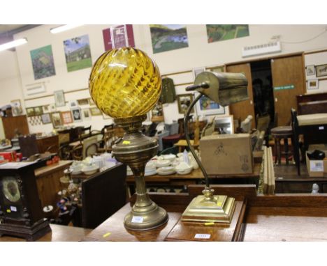 A brass oil lamp with coloured glass shade; together with a brass desk lamp