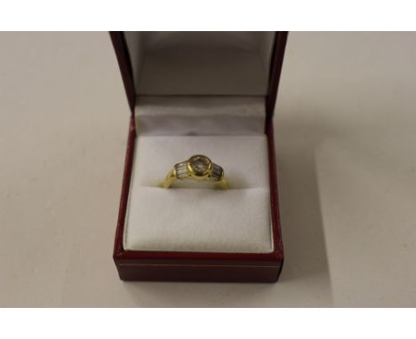 A yellow metal and diamond set ring