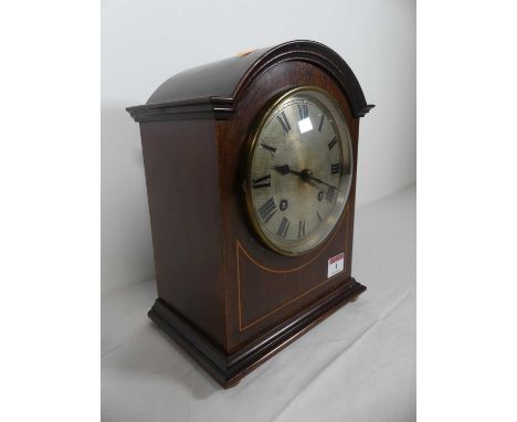 An early 20th century mahogany and boxwood strung mantel clock, the silvered dial showing Roman numerals, having an eight day