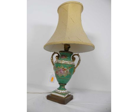 A porcelain table lamp, in the form of an urn, decorated with flowers upon an apple green ground, height 53cm including shade