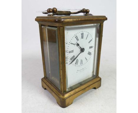 A lacquered brass cased carriage clock, having a visible platform escapement, the white enamel dial showing Roman numeral mar