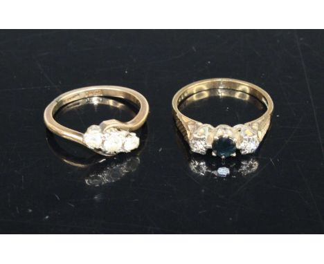 A 9ct gold and moissanite set three-stone ring, size K; together with a 9ct gold, sapphire and diamond point set three-stone 