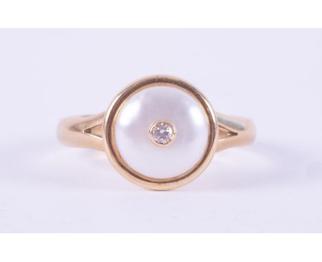 A yellow gold ring (not hallmarked or tested) set with a circular maybe pearl, 9mm diameter &amp; set centrally with a round 