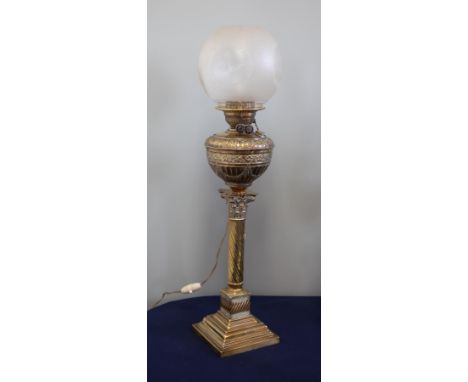 A electric lamp with brass reservoir and a glass shade on twisted base, height 73cm.