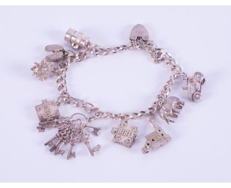 A silver heart padlock charm bracelet with nine silver charms attached including a hedgehog, tractor, keys, elephant, Postbox