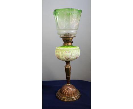 A Victorian oil lamp with green glass column and a green glass shade on a brass base, height 60cm.