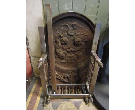 A heavy vintage cast iron fire back of arched form with relief detail of winged cherubs with hammers working at an anvil, tog