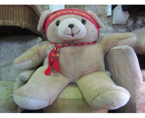 A very large child's soft toy Teddy bear wearing a knitted hat and scarf, retailed by Harrods