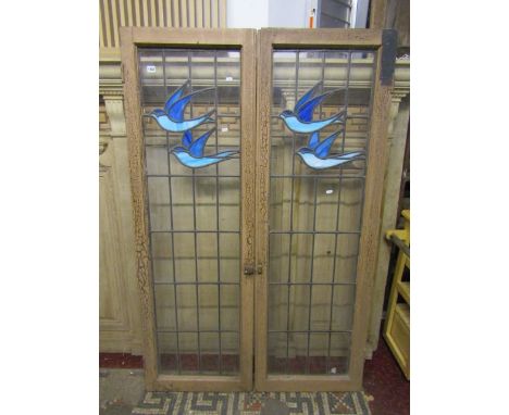 A pair of cabinet doors of rectangular form, the painted and distressed wooden frames enclosing leaded light panels with deco