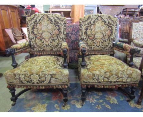 A pair of Victorian open armchairs with floral tapestry upholstered seats, backs and arm pads, shaped outline and carved styl