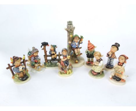 A collection of Goebel Hummel figures of children including a child on a sledge, a girl with chickens, a girl writing on a sl