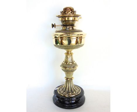 A Victorian polished brass oil lamp with fluted waisted column upon a polished black slate base inscribed number 2 Hinkslever