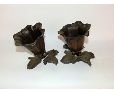 A pair of cast bronze vases in the form of open flowers upon cast leaf bases, each 17.5cm high (2)