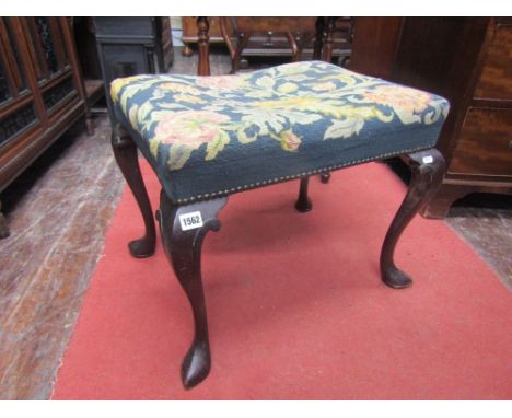 A late 19th century mahogany stool in an 18th century style with pronounced cabriole supports, set beneath a hand worked tape