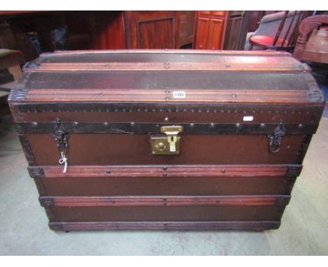 A Victorian domed top and timber lathe bound trunk/chest with reinforced steel bands, side carrying handles, together with a 