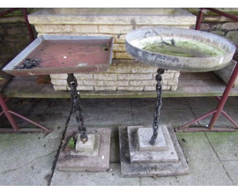 A novelty bird bath, the circular galvanised tin top raised on a welded chain link column and square stepped composition ston