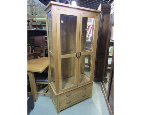 A good quality contemporary light oak display cabinet, partially enclosed by a pair of three quarter length twin rectangular 