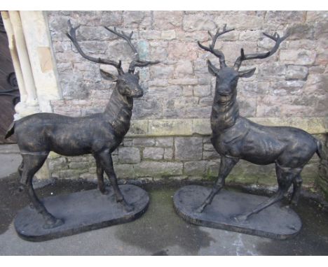 A pair of large garden statuary in the form of stags in standing pose raised on oval/D end platform bases, cast iron with sim