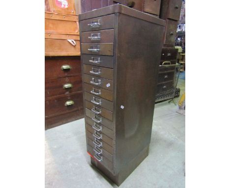 A vintage steel filing cabinet fitted with fifteen shallow index drawers raised on a plinth