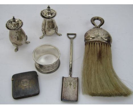 A mixed lot of bijouterie type silver to include two blustered peppers, a silver handled brush decorated in relief with cheru