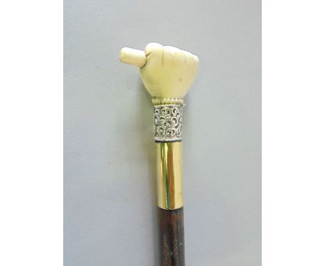 Walking stick with a knop in the form of a hand holding a baton, with silver collar and brass foot