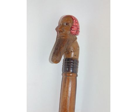 A walking stick carved with the head of a court judge, with polychrome detail