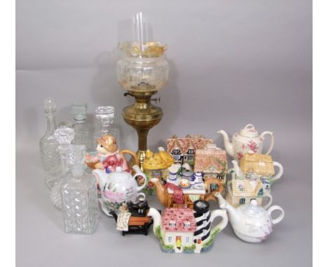 A collection of novelty tea pots, various glass decanters and stoppers, a brass oil lamp with etched floral shade, etc,