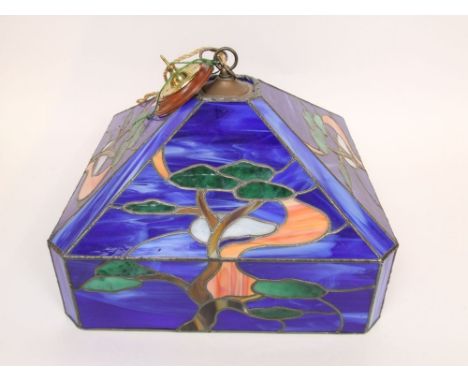 Tiffany style leaded colour glass light shade decorated in the art nouveau style with trees upon a blue ground, 44cm wide
