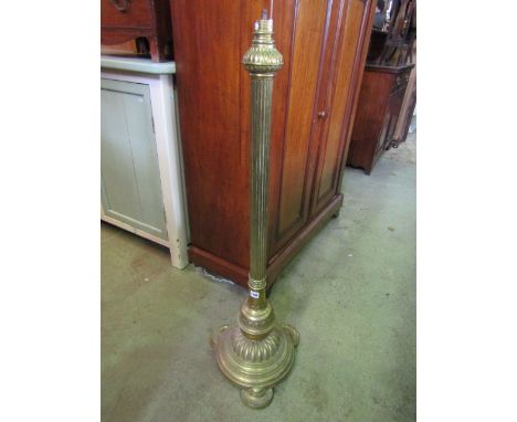 A Victorian brass lamp standard with partially reeded column, domed disc shaped platform base and flattened feet