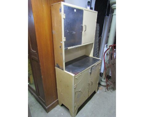 A vintage partially stripped aluminium kitchen cabinet, freestanding and enclosed by two pairs of doors divided by a central 