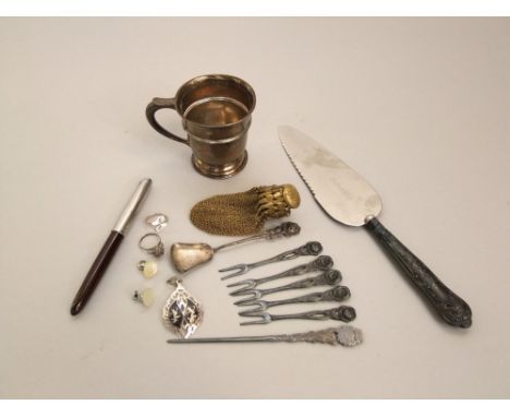 A mixed lot to include a silver helmet christening cup, a silver handled cake knife, various eastern white metal jewellery, g