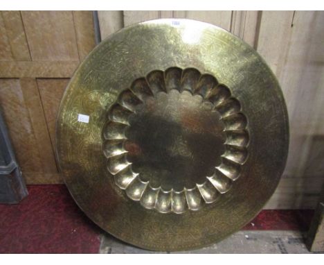 A large Eastern brass tray/charger of circular form with engraved detail, together with a framed and glazed mezzotint depicti