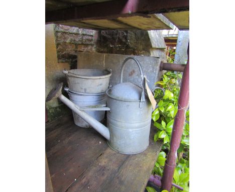 A small reclaimed galvanized steel water tank/cistern with pop riveted seams together with vintage galvanized watering can an